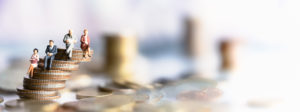 miniature people sitting on stacks of coins